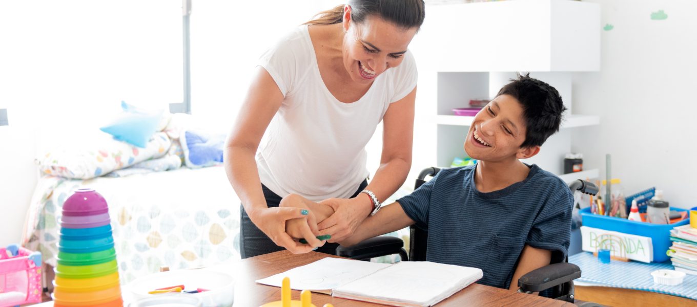 Mother playing with son with Cerebral Palsy Mother drawing with son with Cerebral Palsy